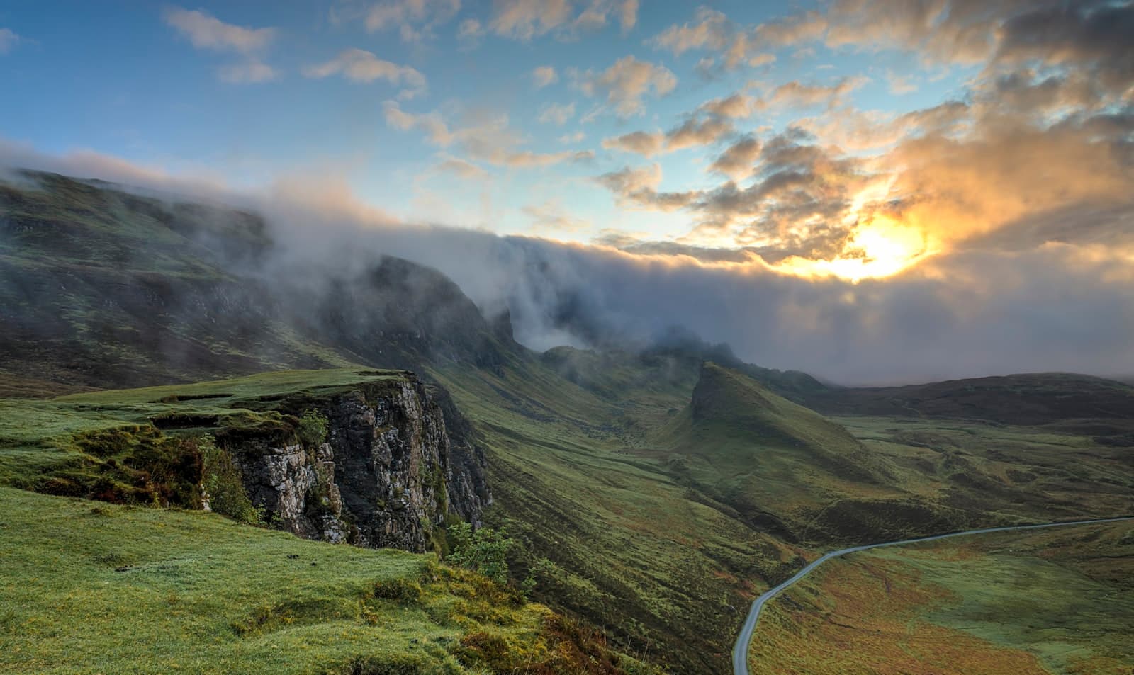 Winding mountain road through misty hills