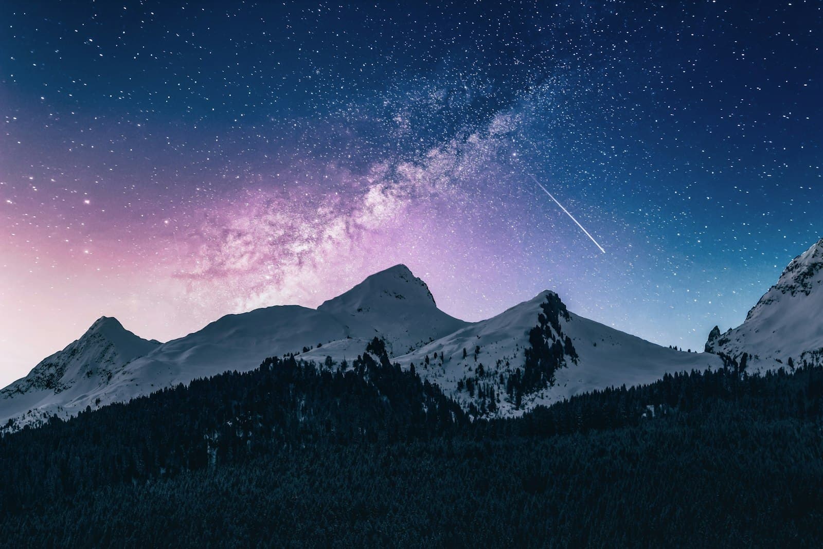 Starry night sky over mountain peaks