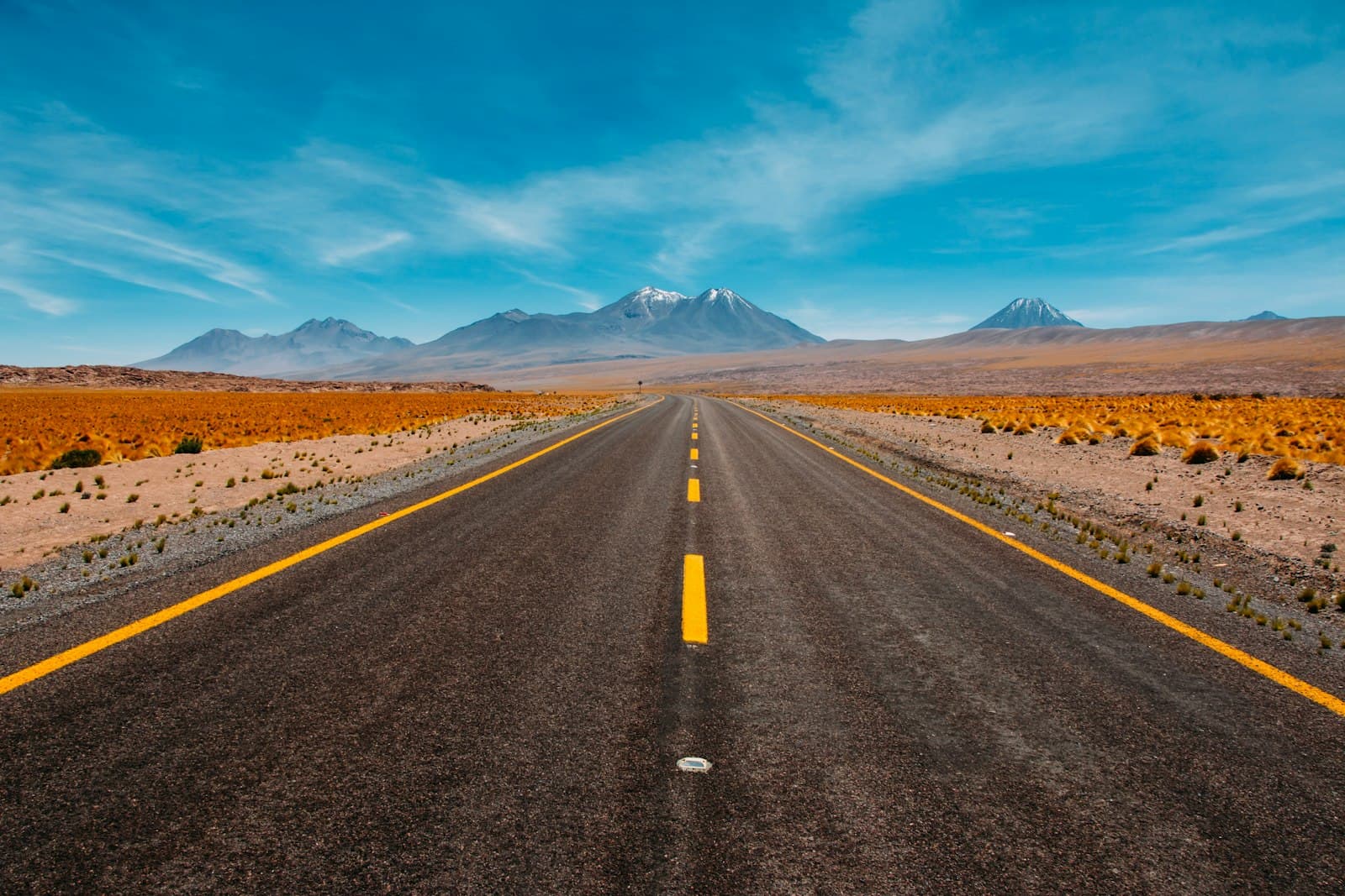 Open highway stretching toward distant mountains at sunset